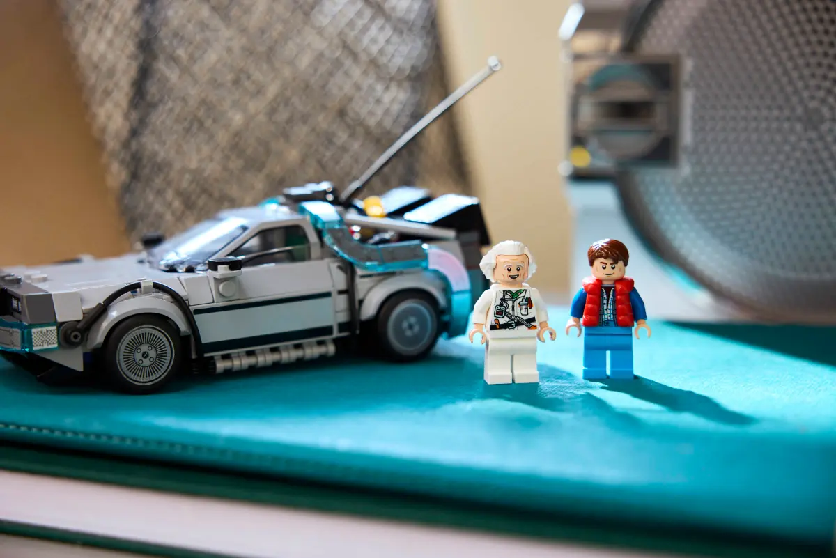 Doc Brown e Marty McFly in primo piano con la DeLorean sullo sfondo